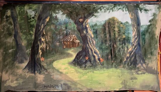 Forêt de feuillus avec une cabane de sorcières; des renards pointent leur tête et regardent le chemin