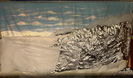 Collines enneigées sous un ciel bleu avec quelques nuages, village en arrière-plan