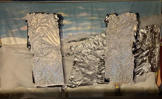 Collines enneigées sous un ciel bleu avec quelques nuages, rochers d'argent sur la droite et deux rochers d'argent verticaux