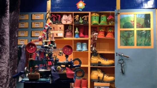 Atelier de cordonnier avec chaussure sur des étagères et machine à coudre au premier plan