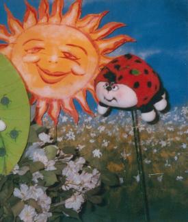 Une coccinelle et le soleil, sur fond de pré et un ciel bleu